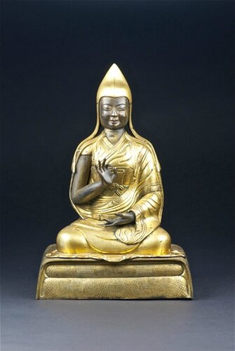 An magnificent gilt-bronze repousse figure of the Sixth Panchen Lama, seated on a decorated double pillow base