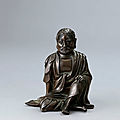 A silver-inlaid bronze figure of a luohan, qing dynasty, 18th century