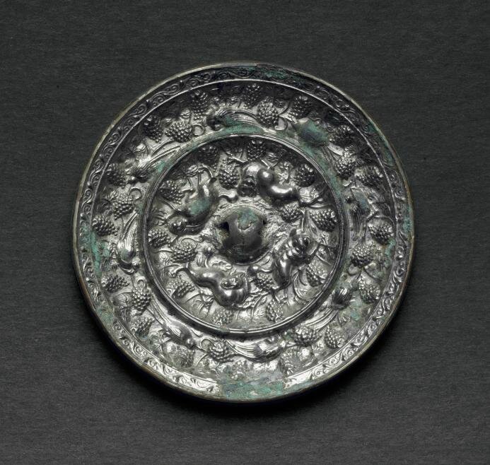 A silvery bronze circular  'Lion and grapevine' mirror, Tang dynasty (AD 618-907)