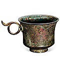 A gilt-bronze 'floral' cup with handles, tang dynasty (618-907)