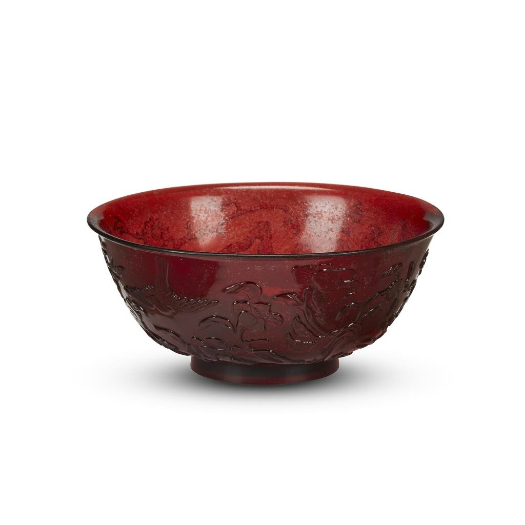 A Chinese ruby glass bowl, carved with birds among flowering branches, Four-character qianlong mark and probably of the period